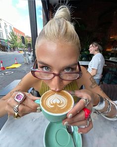 a woman holding a cup of coffee in front of her face