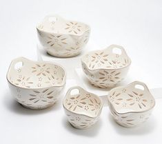 four white ceramic bowls with holes in them