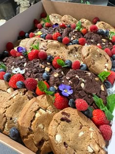 a box filled with cookies and berries on top of a table