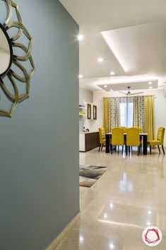 a dining room with yellow chairs and a large clock on the wall above it's doorway