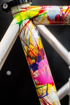 a close up of the handle bars on a colorful bike with paint splattered all over it