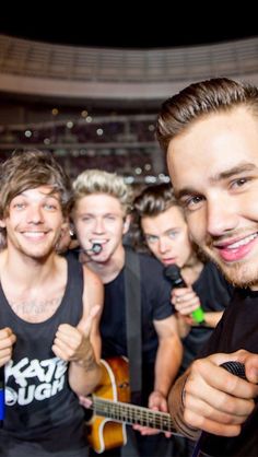 a group of young men standing next to each other in front of a stage with the caption steal my girl one direction