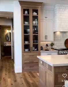 a large kitchen with white cabinets and wood flooring is pictured in this image from the front view