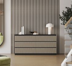 a living room with a green chair and a black cabinet in front of the wall