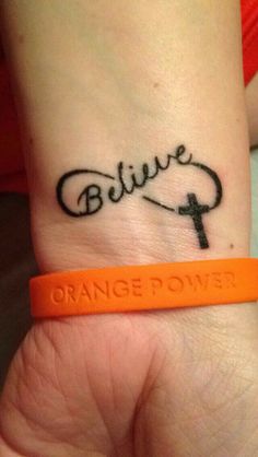 a wrist tattoo with the word believe on it and a cross in black ink that reads, orange powers