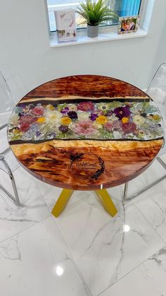 a wooden table with flowers on it in front of a window