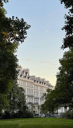 a large white building surrounded by trees and grass