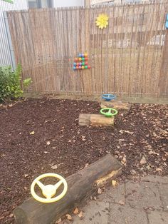 a wooden bench sitting in the middle of a yard next to a fence and tree stump