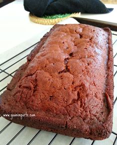 a loaf of chocolate cake sitting on top of a cooling rack