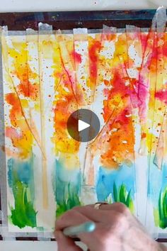 someone is painting trees with watercolors on paper