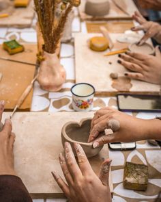 several people are making pottery on a table