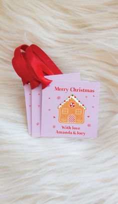 three pink christmas cards with red ribbon on white fur