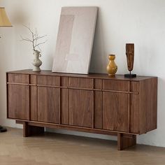 a large wooden cabinet sitting next to a lamp on top of a hard wood floor