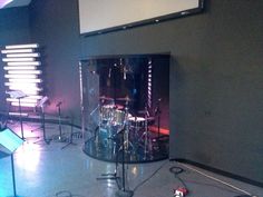 a drum set up in the middle of a room with microphones and music equipment