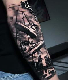 a man with a black and white tattoo on his arm that has an airplane in the sky