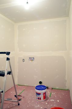 a room that is being remodeled with paint on the walls and a ladder next to it