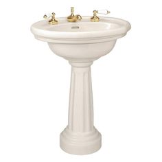 a white pedestal sink with three faucets on it