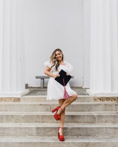 a woman is posing on some steps