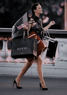 a woman walking down the street carrying shopping bags