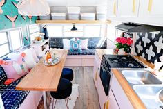 the interior of a camper is decorated in pink, blue and white