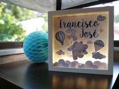 a light up frame with an elephant and hot air balloons in the sky on a table