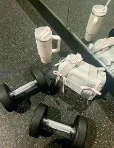 a pair of shoes and some dumbbells are on the floor in front of a mirror