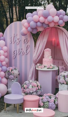 a pink and purple birthday party with balloons, cake and flowers on the table in front of it