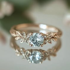 an engagement ring with a blue diamond in the center and leaves on it's side