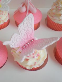 cupcakes with pink frosting and white icing, decorated like a butterfly