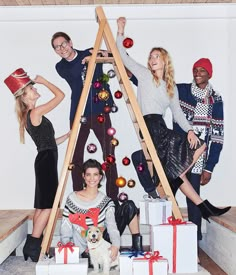 three women and one man are posing for a christmas photo