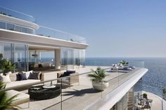 a balcony overlooking the ocean with couches and chairs