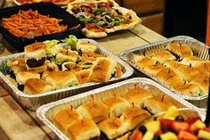 many trays of food are on the table ready to be served at a party