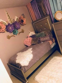 a bedroom with a bed, dresser and flowers on the wall above it's headboard