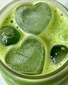 a green drink with heart shaped bubbles in it