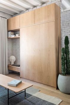 a living room with a couch, coffee table and bookshelf next to a brick wall