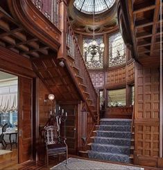 an ornate wooden staircase leads up to the second floor