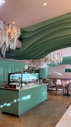 the interior of a restaurant with chandeliers hanging from the ceiling and green walls