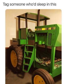 a green tractor bed sitting in the middle of a room next to a white wall