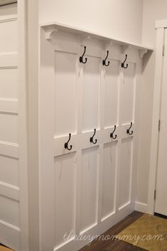 an image of a white coat rack with hooks on it and the caption board and batten entryway