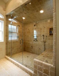 a walk in shower sitting under a window next to a bathtub with glass doors