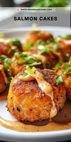 salmon cakes on a white plate with sauce drizzled over them and garnished with green onions