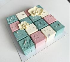 a close up of a square cake with flowers on the top and bottom, decorated in pastel colors