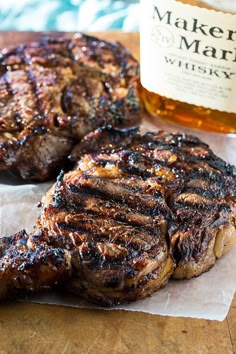 two steaks and a bottle of maker's mark whiskey