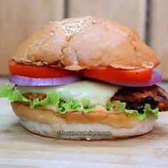 a chicken burger with lettuce, tomato and onion