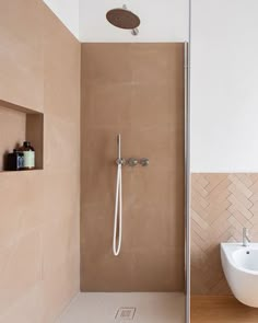 a bathroom with a sink, toilet and shower head mounted to the side of the wall