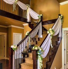 a staircase decorated with white flowers and greenery