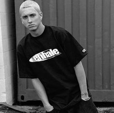 a young man standing in front of a building with his skateboard on the ground