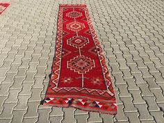 a long red rug is laying on the ground