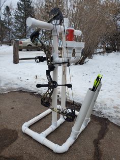 the bow stand is made out of pipes and plastic tubes, which are attached to trees