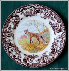 a brown and white plate with a painting of a fox on it's side